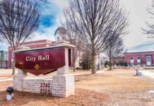 City Hall sign in front of a red-brick municipal building
