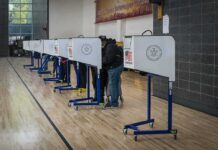 Voter Data Ripped — Prosecutors Go Silent Voters at polling booths in a gymnasium