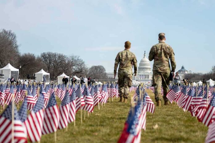 shutterstock_1899676156 Two soldiers walk among American flags toward the U.S. Capitol