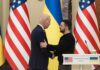 Two men shake hands at a podium with U.S. and Ukrainian flags