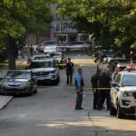 Testicle Trafficking Lie Turns Deadly Police officers secure a residential street with patrol cars and yellow tape