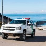 Trump-Tied Water Win Stuns Farmers Border patrol SUV parked near beach fence