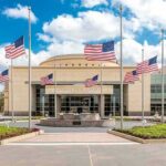American flags at half-staff around a library entrance