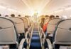 airplane cabin with passengers seated in economy class