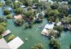 Flooded Street Horror: Dorsal Fin Appears Aerial view of flooded neighborhood with rescue boat navigating streets