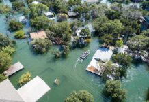 Aerial view of flooded neighborhood with rescue boat navigating streets