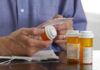 Person holding a prescription bottle and reading medical instructions