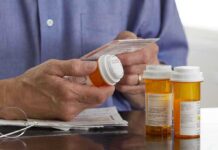 Person holding a prescription bottle and reading medical instructions