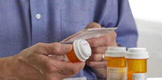 Person holding a prescription bottle and reading medical instructions