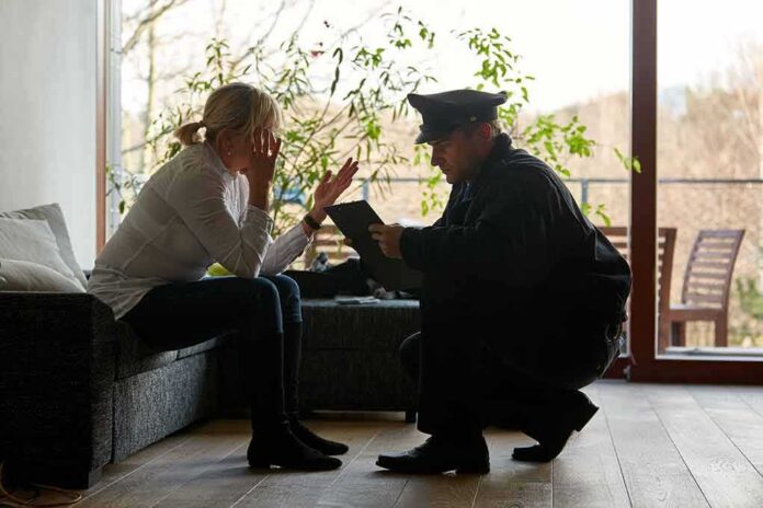 police officer speaking with distressed woman on a sofa
