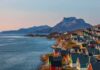 Trump Claims PERMANENT Arctic Control Colorful coastal town with mountains and sea at sunset
