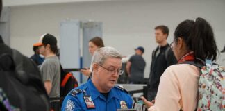 Bill Bergey, a TSA officer, checks a traveler's documents at an airport security checkpoint
