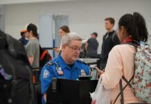 tsa officer checks a traveler's documents at airport security