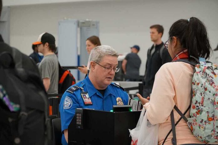 tsa officer checks a traveler's documents at airport security
