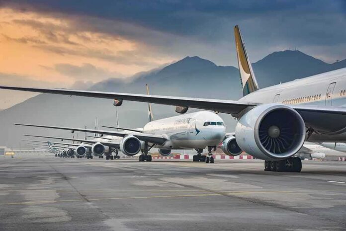 shutterstock_1684279723 Commercial airliners lined up on an airport taxiway at dusk