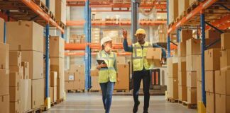 Warehouse workers walking among shelves with boxes