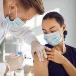 Aging America Triggers Massive Job Shift Healthcare worker giving a masked patient a vaccine in the upper arm