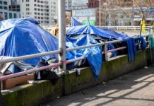 City Hazmat Storms Camp After Mysterious Death Tents covered with blue tarps along a city sidewalk