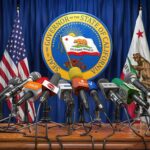 Press microphones at a podium before California governor seal