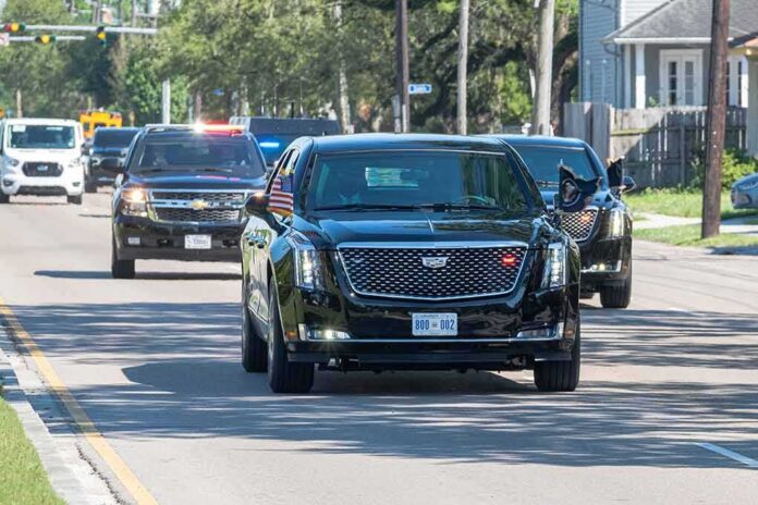 shutterstock_1969534900 Motorcade of black SUVs and sedans driving down a city street