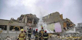 Firefighters search rubble of a partially collapsed building