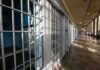 Row of empty prison cells with metal bars