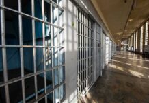 Row of empty prison cells with metal bars
