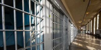 Row of empty prison cells with metal bars