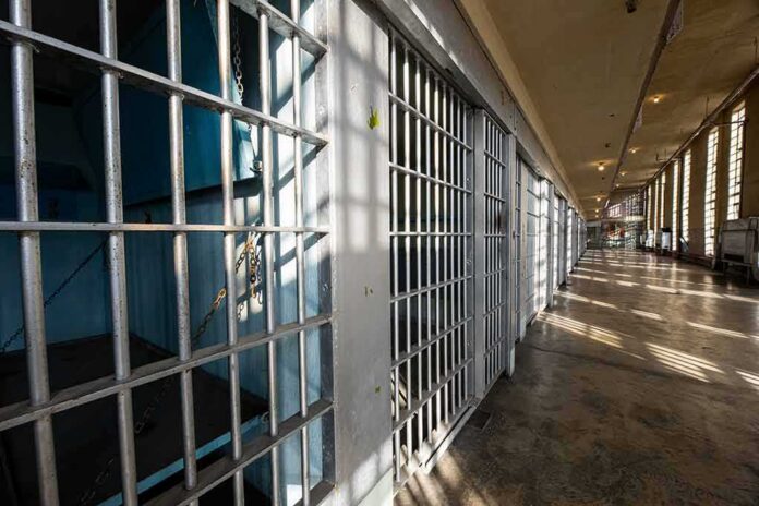 Row of empty prison cells with metal bars