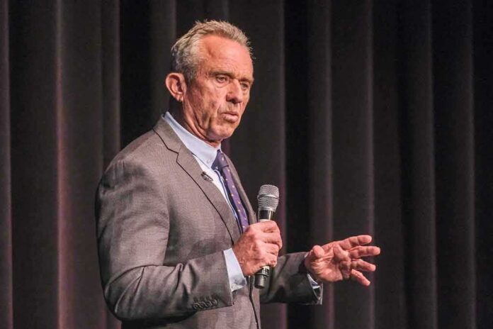 man in a suit speaking into a microphone on stage