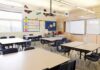 Absentee Crisis Triggers Citywide Overhaul Empty classroom with tables, chairs, and a whiteboard