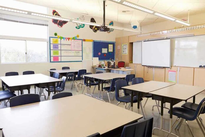 Empty classroom with tables, chairs, and a whiteboard