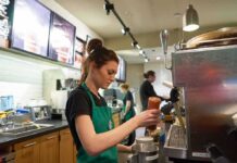 Surprise Hiring Surge Shocks Wall Street Barista preparing a drink at a coffee shop counter