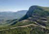 Winding mountain road with sharp switchbacks on a green hillside