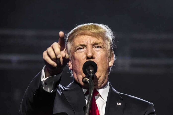 man speaking at a microphone and pointing forward