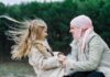 Woman in headscarf and girl holding hands outdoors