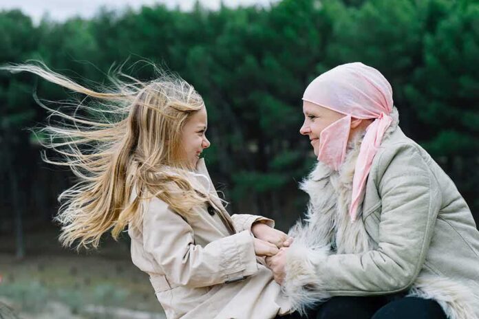 Woman in headscarf and girl holding hands outdoors