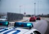 Police car with blue lights on near a roadway