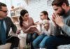 Family and counselor in tense discussion with upset child holding teddy bear