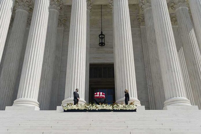 shutterstock_1820477594 Flag-draped casket on courthouse steps between towering columns