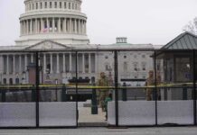 US Capitol behind security fence with guards