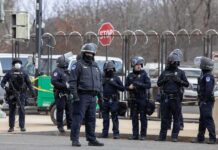 Bombers’ Base Targeted? Iran Murmurs Grow Group of police officers in riot gear standing on a street; Brian Folkerts present