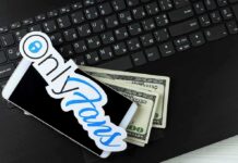 Smartphone with OnlyFans sticker and cash on a laptop keyboard