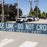 Daylight Horror Shocks Chicago Police line barrier blocking a street with patrol vehicles behind
