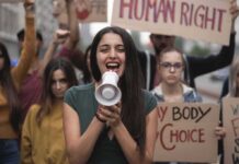 Young woman leading a protest with a megaphone