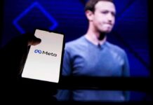 Zuckerberg’s Tax Shield Sparks Outrage Mark Zuckerberg on screen with a hand holding a phone showing the Meta logo