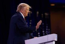 Election Shock: Cash For Convictions Donald Trump speaking at a podium with hand raised