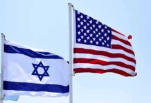 Israeli and American flags waving on poles