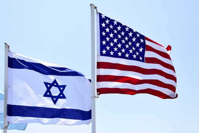 Israeli and American flags waving on poles
